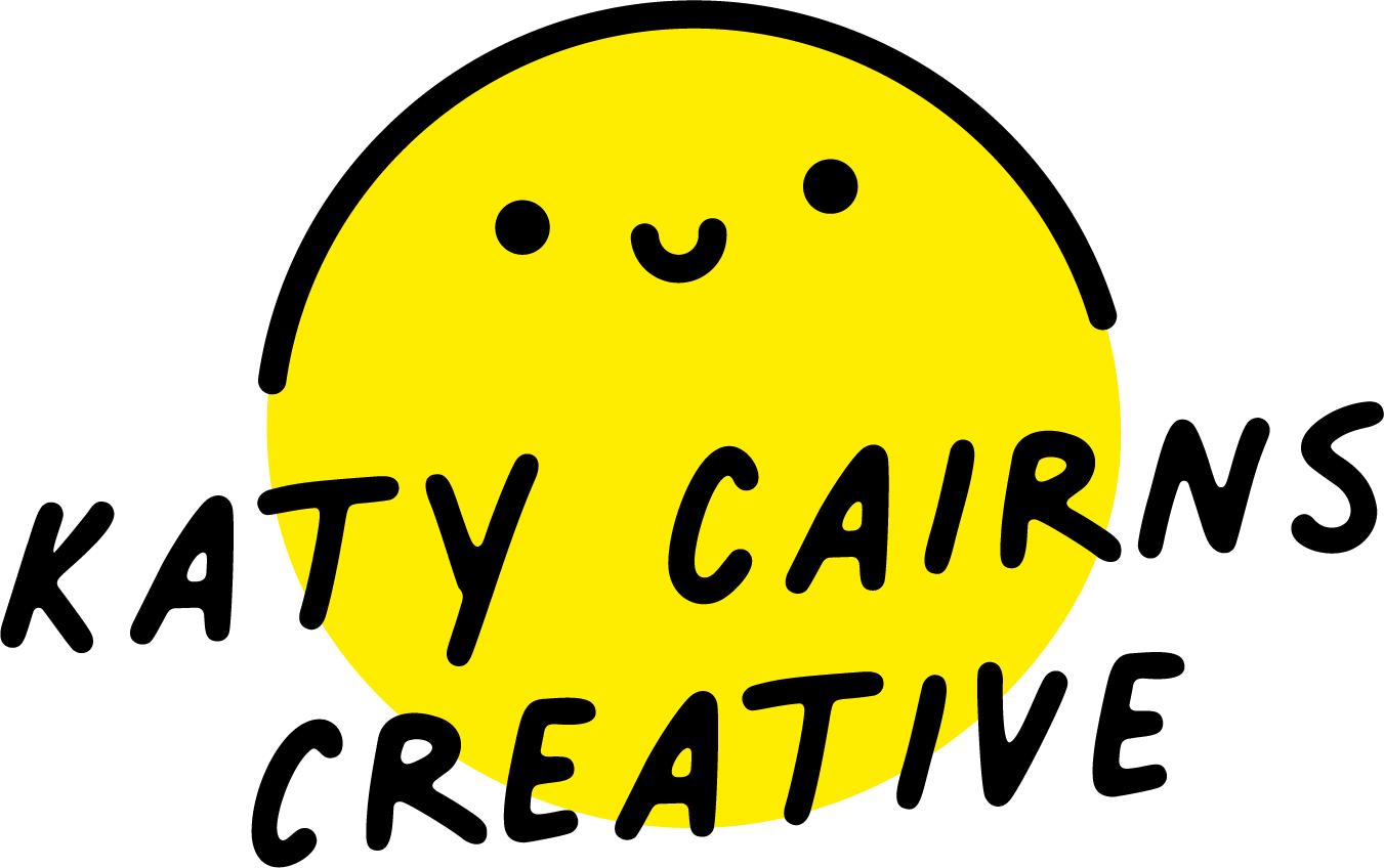 Logo of a little happy face in a yellow circle with the text 'Katy Cairns Creative'